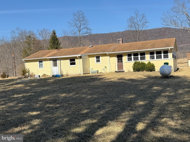 view of front of property with a front yard and a chimney