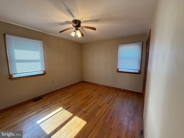 unfurnished room with baseboards, visible vents, light wood finished floors, and ceiling fan