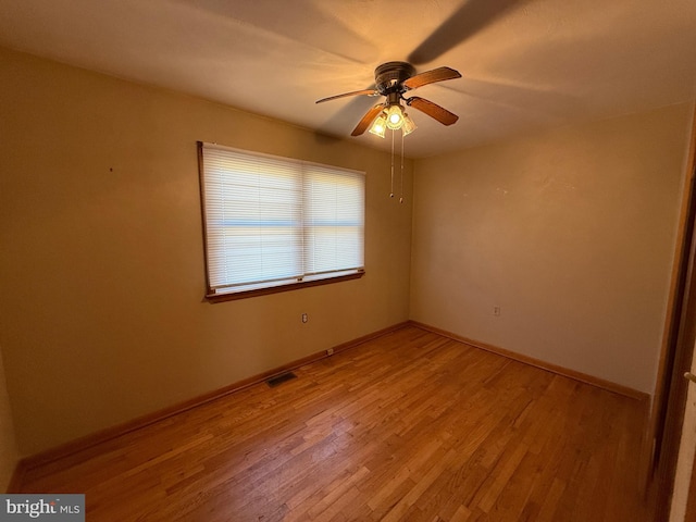 spare room with visible vents, light wood-style flooring, baseboards, and ceiling fan