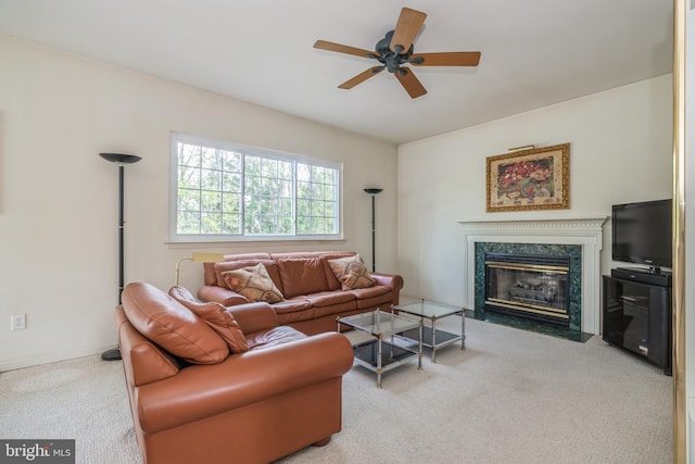 living room featuring a fireplace, light carpet, and ceiling fan