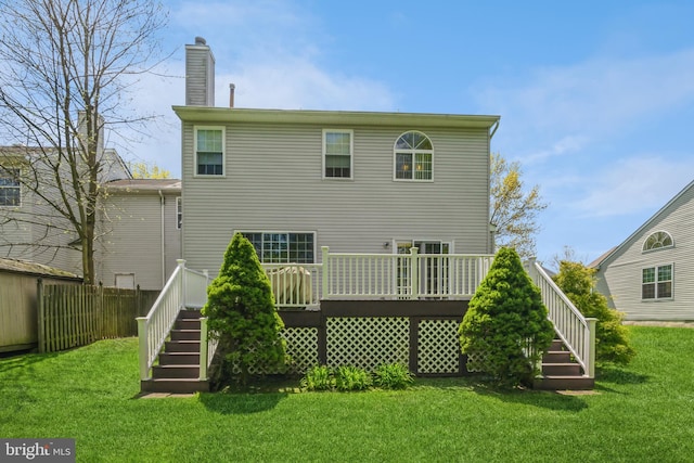 back of property featuring a deck and a lawn