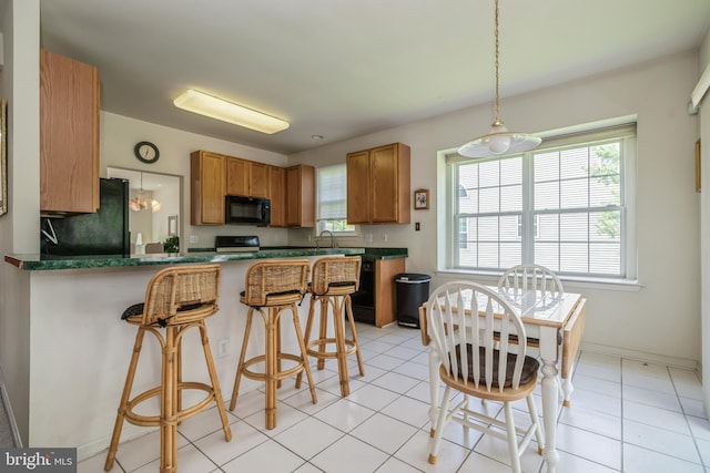 kitchen featuring kitchen peninsula, backsplash, sink, black appliances, and light tile patterned floors