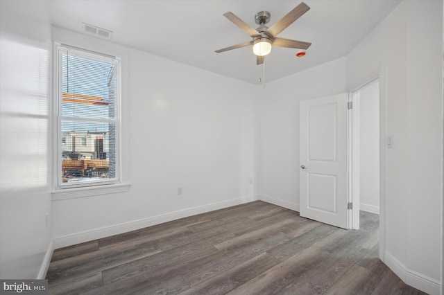 spare room with ceiling fan and dark hardwood / wood-style floors