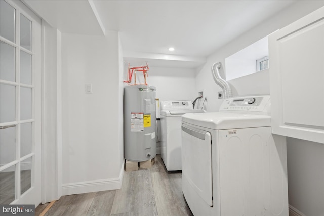 laundry area with light wood-type flooring, electric water heater, and washer and dryer