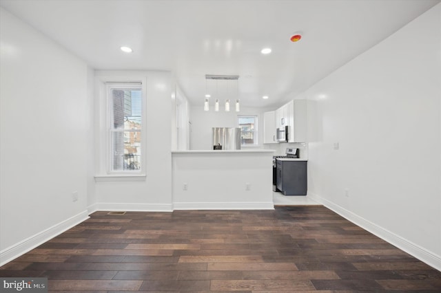 unfurnished living room with plenty of natural light and dark hardwood / wood-style floors