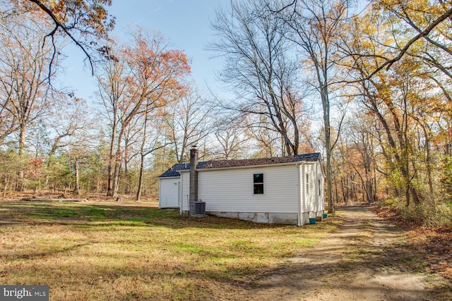 view of outbuilding with a yard and central air condition unit