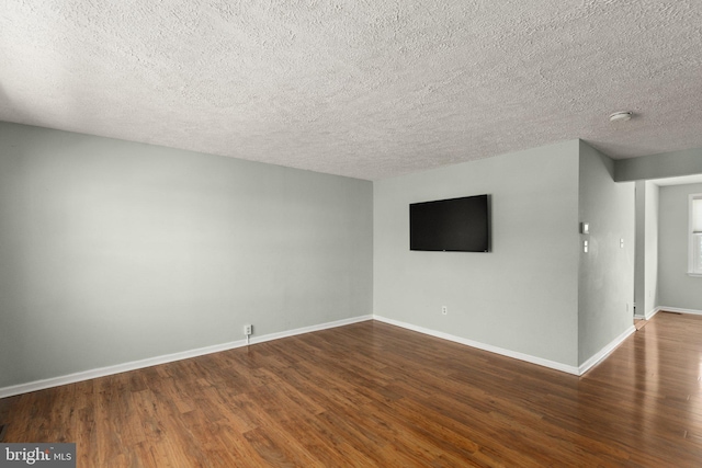 unfurnished room with wood-type flooring and a textured ceiling