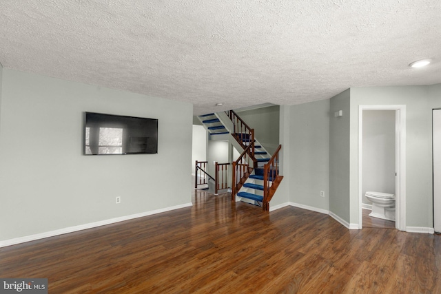 unfurnished living room featuring dark hardwood / wood-style flooring and a textured ceiling