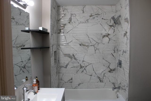 bathroom featuring tiled shower / bath and vanity