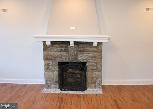 details with a stone fireplace and hardwood / wood-style floors