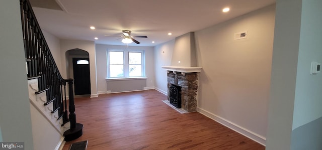 unfurnished living room featuring ceiling fan, dark hardwood / wood-style floors, and a fireplace