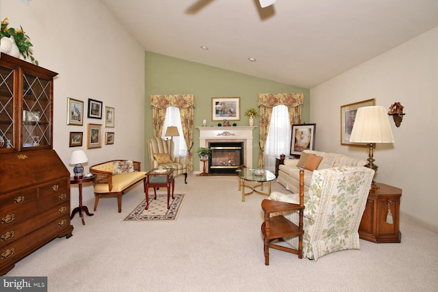 sitting room with light carpet, vaulted ceiling, and ceiling fan