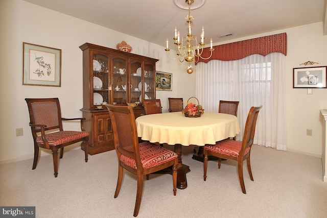 dining area featuring light carpet and an inviting chandelier