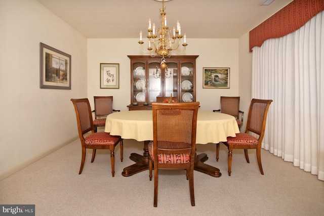 dining space featuring light colored carpet and a notable chandelier