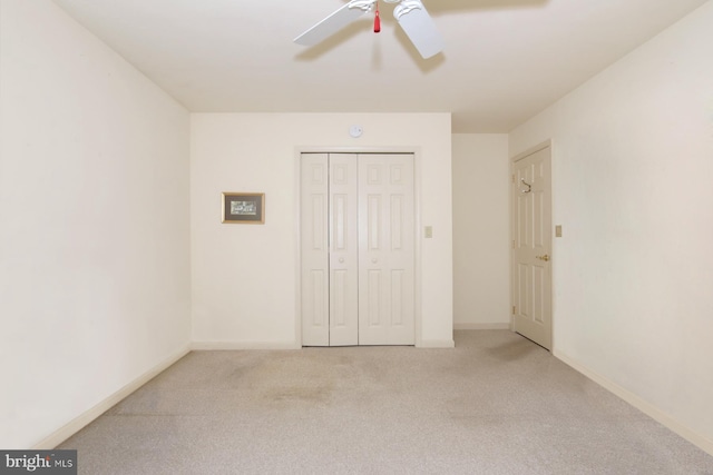 unfurnished bedroom featuring ceiling fan, light carpet, and a closet