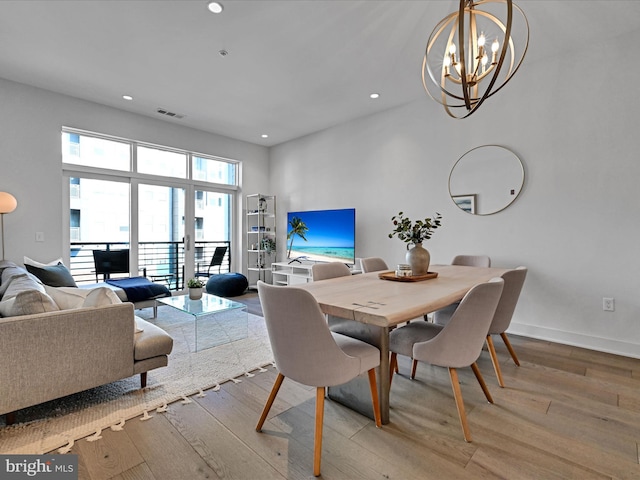 dining room with an inviting chandelier and light hardwood / wood-style flooring