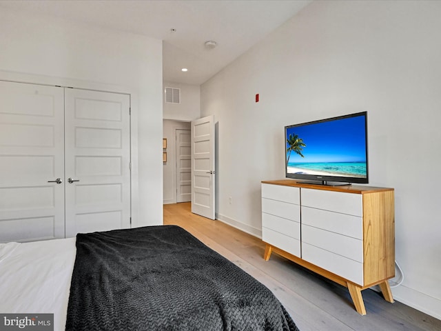 bedroom with light wood-type flooring and a closet