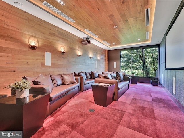 carpeted cinema room featuring wood ceiling and wooden walls