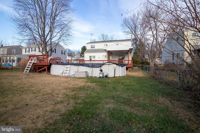 back of property with a lawn and a pool side deck