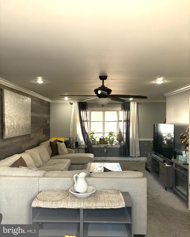 living room with ceiling fan, carpet floors, and ornamental molding