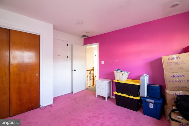 bedroom with light colored carpet and a closet