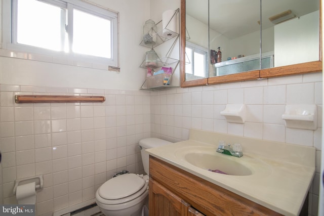 bathroom with vanity, tile walls, and toilet