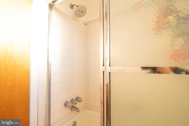 bathroom featuring combined bath / shower with glass door