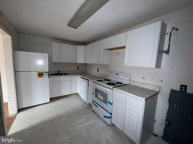 kitchen with white cabinets, white appliances, sink, and a textured ceiling