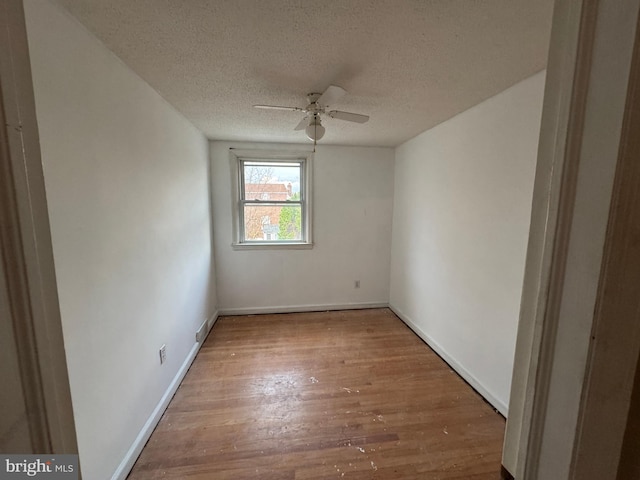 spare room with ceiling fan, wood-type flooring, and a textured ceiling