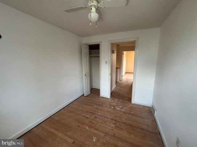 unfurnished bedroom with a closet, ceiling fan, and dark hardwood / wood-style floors