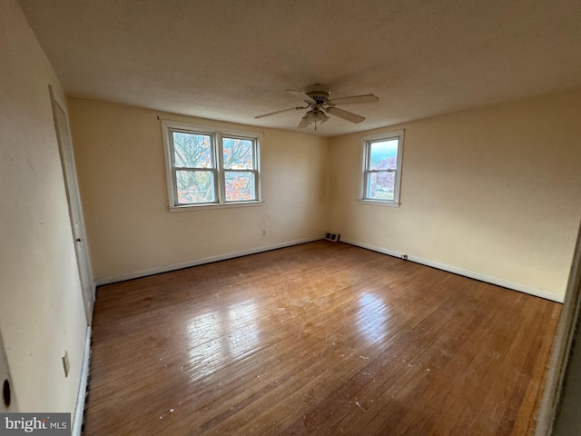 spare room with hardwood / wood-style floors, plenty of natural light, and ceiling fan