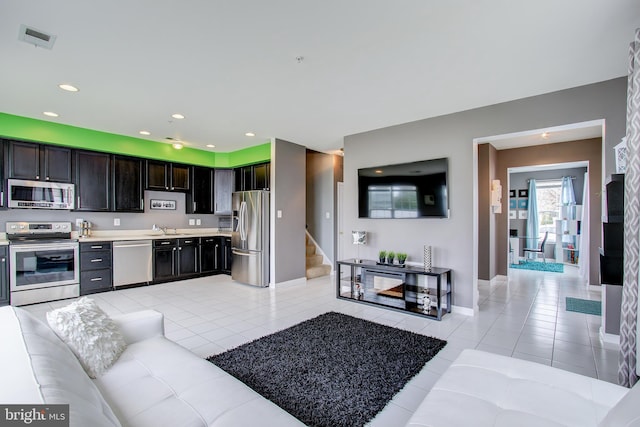 living room featuring sink and light tile patterned floors