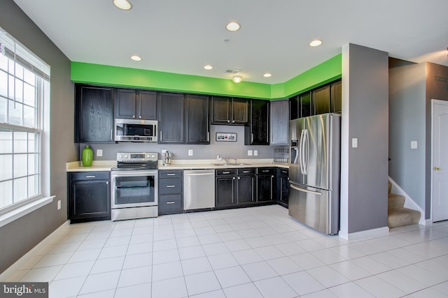 kitchen with sink, light tile patterned floors, and appliances with stainless steel finishes