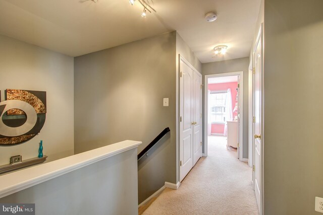 corridor featuring light colored carpet