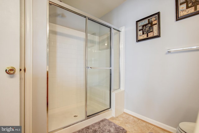 bathroom featuring tile patterned floors, toilet, and an enclosed shower