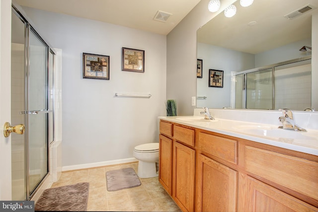 bathroom featuring toilet, vanity, tile patterned floors, and an enclosed shower