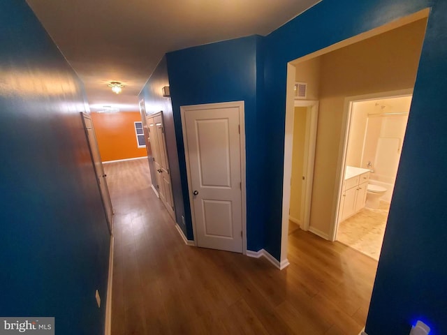 hallway with hardwood / wood-style flooring