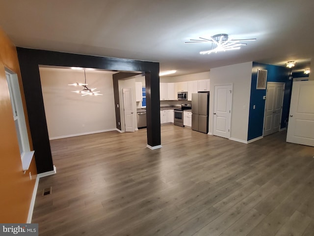 unfurnished living room featuring hardwood / wood-style flooring and ceiling fan