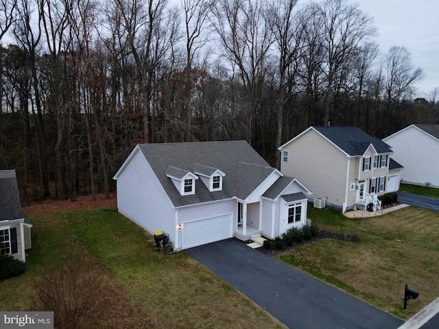 view of front of property featuring a front lawn, an attached garage, and aphalt driveway