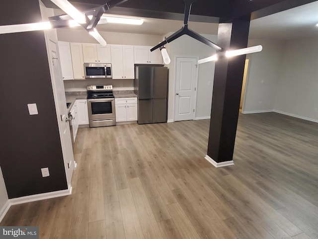 kitchen featuring white cabinets, appliances with stainless steel finishes, and light hardwood / wood-style flooring