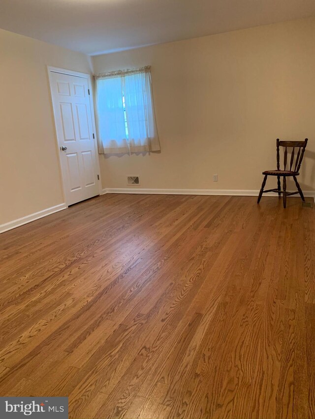 unfurnished room with wood-type flooring