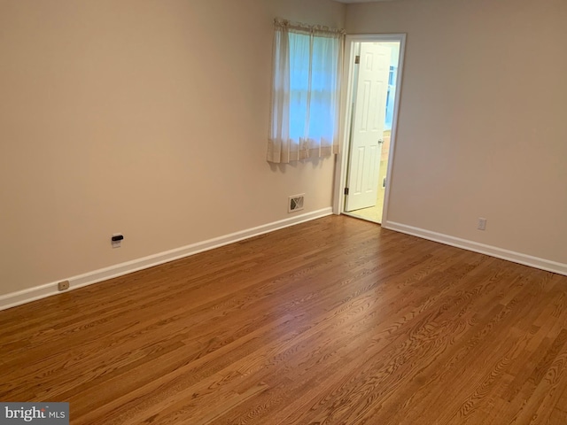 empty room with hardwood / wood-style flooring