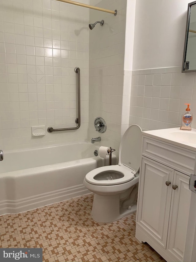 full bathroom featuring tile patterned flooring, toilet, vanity, tile walls, and tiled shower / bath