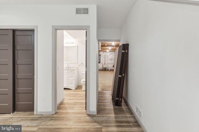 corridor featuring light hardwood / wood-style floors and sink