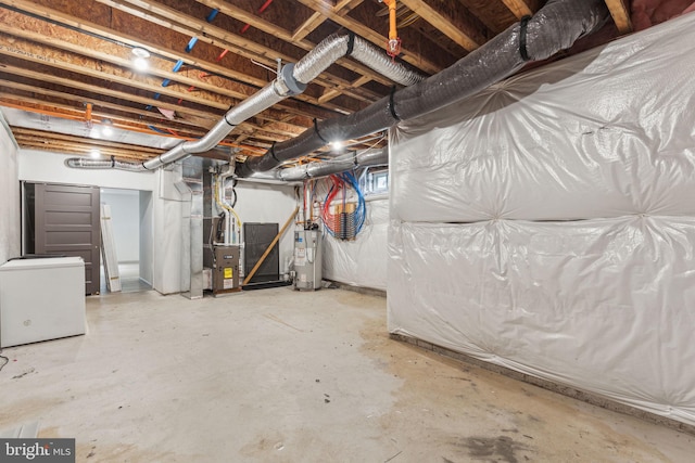 basement featuring refrigerator, gas water heater, and heating unit