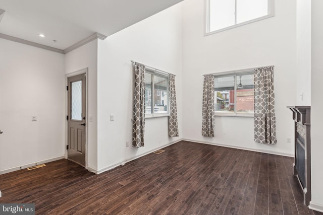 unfurnished living room with dark hardwood / wood-style floors and crown molding