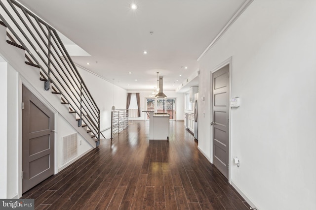 corridor with crown molding and dark wood-type flooring