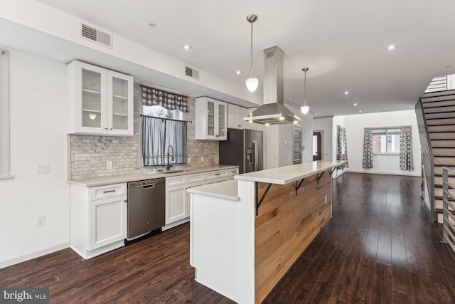 kitchen featuring island exhaust hood, stainless steel appliances, dark wood-type flooring, decorative light fixtures, and a kitchen island