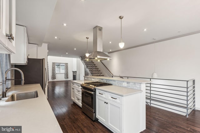 kitchen with island range hood, dark wood-type flooring, pendant lighting, white cabinets, and stainless steel gas stove