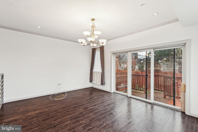 unfurnished dining area featuring ornamental molding, dark wood-type flooring, and an inviting chandelier